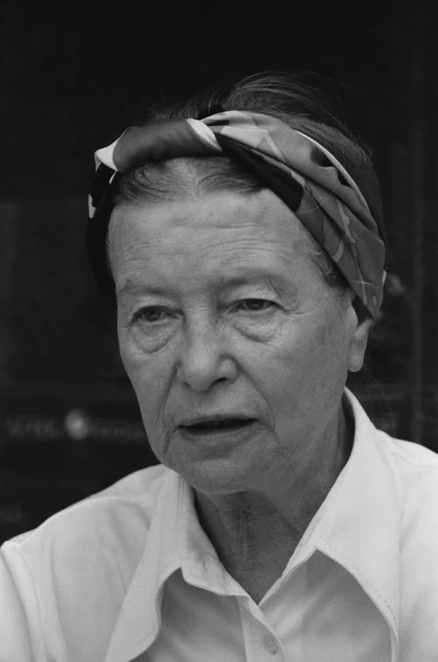 Simone de Beauvoir con una camisa blanca y un pañuelo amarrado en la cabeza