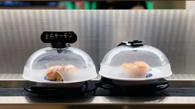 Platos de sushi de salmón en una cinta transportadora en Tokio, Japón.