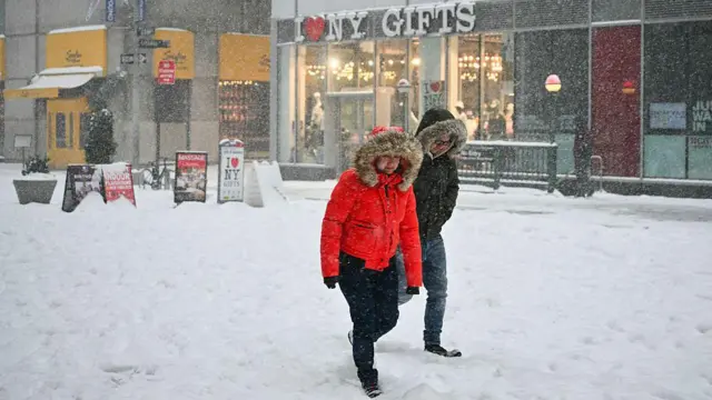 Dos personas caminan por la nieve en la ciudad de Nueva York.