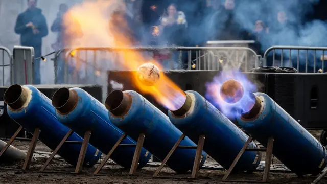 En Ommen, Países Bajos, unos bidones de leche disparan balones de fútbol con mucho fuego por un extremo.
