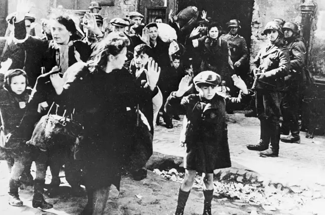 Un grupo de mujeres judías polacas esperan a ser llevadas por soldados alemanes en Varsovia en 1943. Fotografía tomada por un comandante de las SS alemanas, utilizada durante los Juicios de Núremberg como evidencia del terrorismo nazi en la capital polaca.