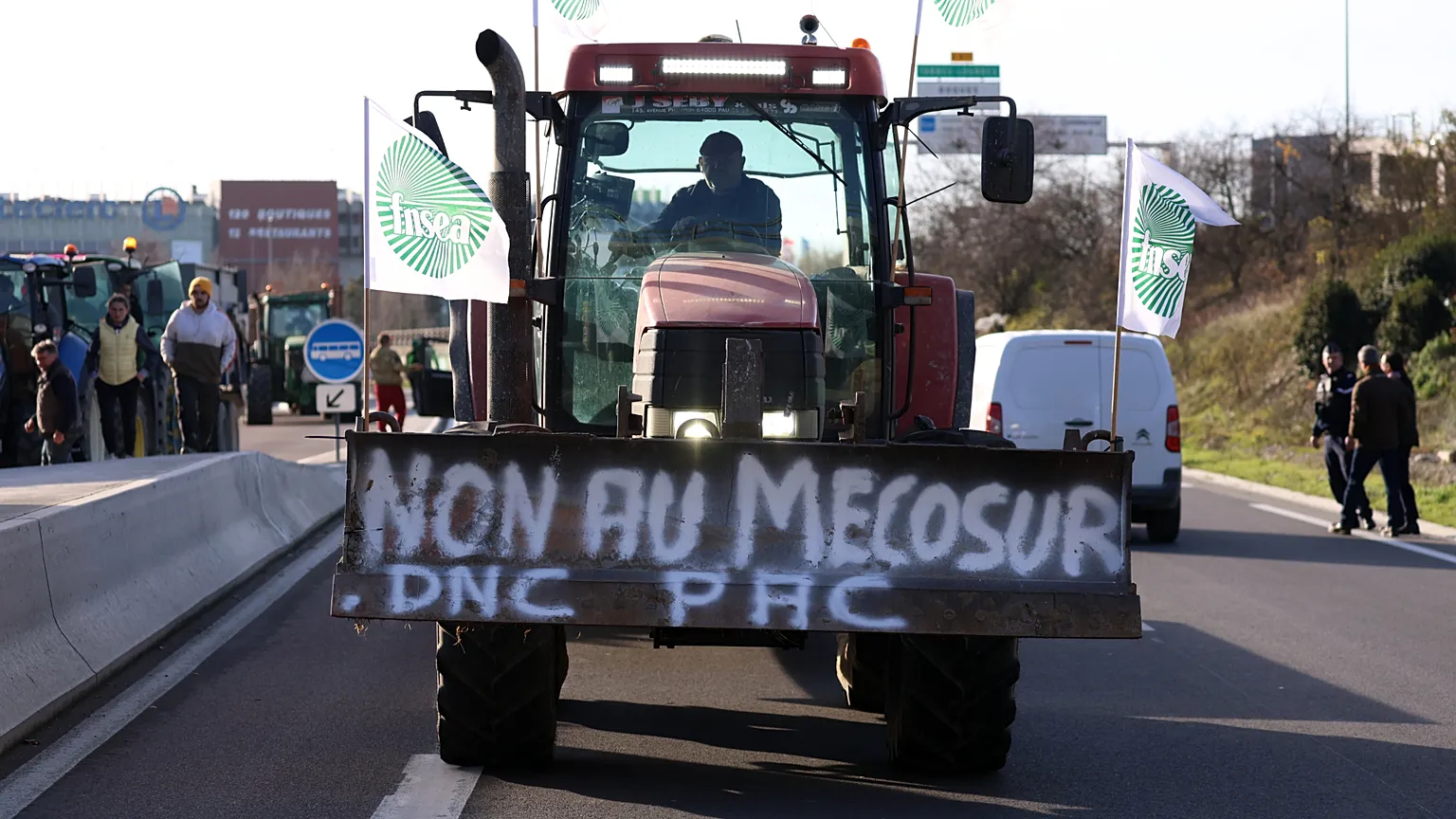 A French farmer drives his tractor to block a main road during a protest against the EU-Mercosur trade deal, Thursday, Dec. 18, 2025