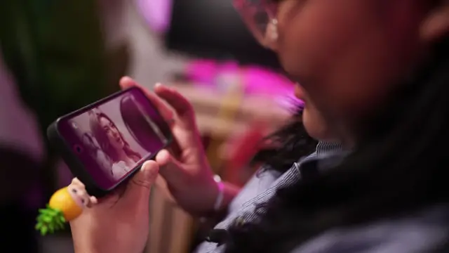 Tan Zie Yee, de Singapur, admira en su celular las estrellas de la serie tailandesa de GL "Nuestro Secreto"