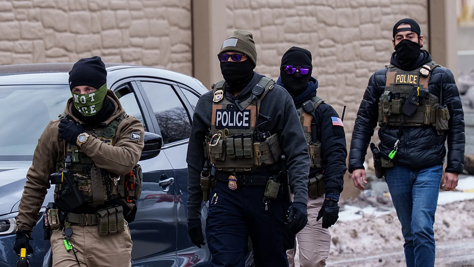 FILE: ICE agents, including one wearing a 'NOT ICE' face covering, walk near their vehicles, Richfield, MN, 15 January 2026