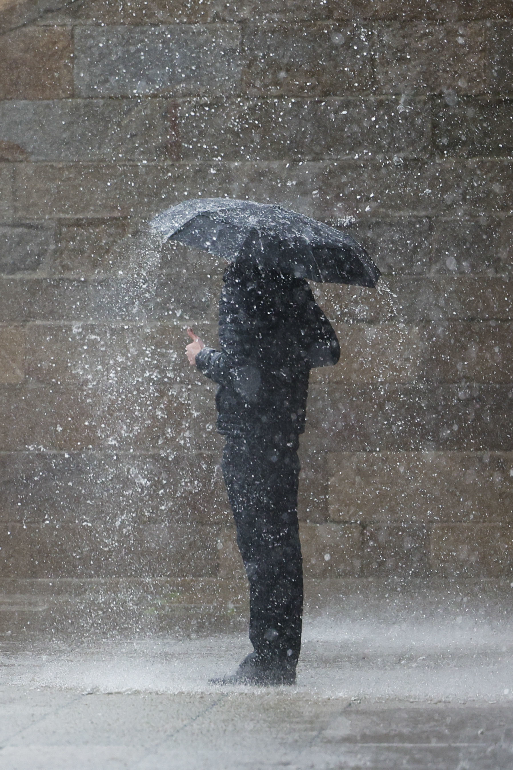 Una persona se protege de la fuerte lluvia en Santiago de Compostela.