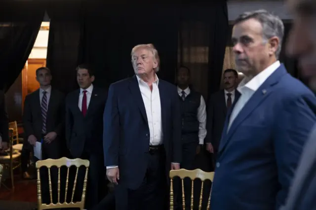 Trump y Ratcliffe parados.