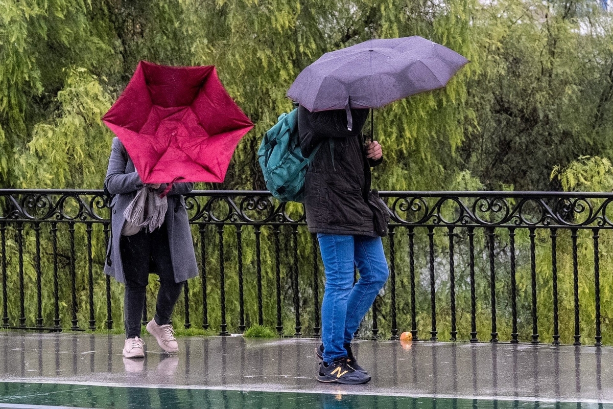 Viandantes afectados por el viento