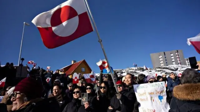 Una manifestación de groenlandeses en Nuuk agitan banderas de su país y sostienen pancartas en contra las intenciones de Donald Trump