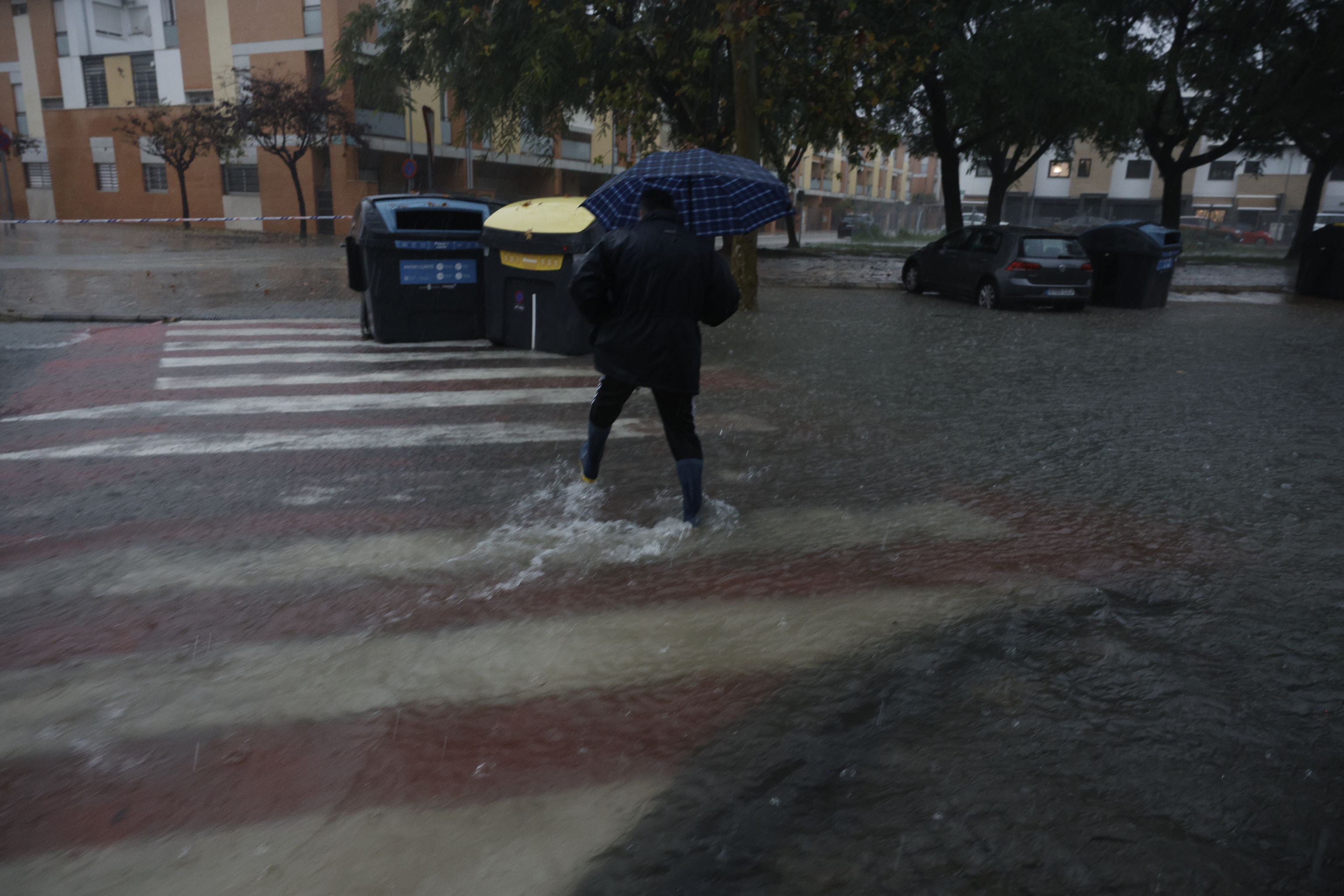 Una persona cruza una calle anegada en la localidad de l'Alcúdia (Valencia).