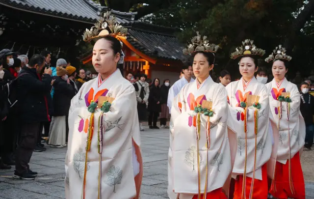 En Osaka, Japón, cuatro jóvenes vestidas con kimonos tradicionales participan en una procesión ritual sintoísta para conmemorar el final del año en Sumiyoshi Taisha, uno de los santuarios sintoístas más antiguos de Japón.