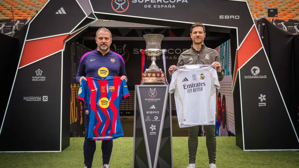 Hansi Flick y Xabi Alonso posan junto al título de la Supercopa de España.
