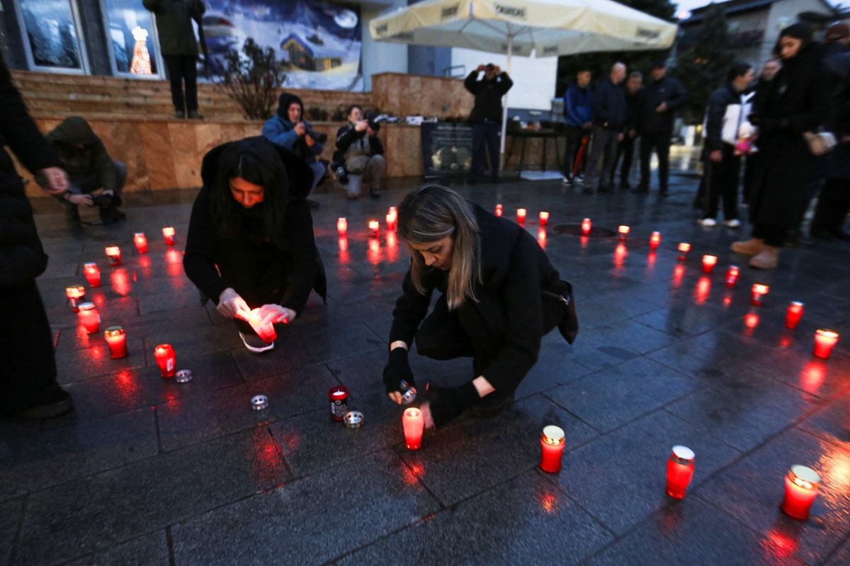 Mujeres encienden velas en el