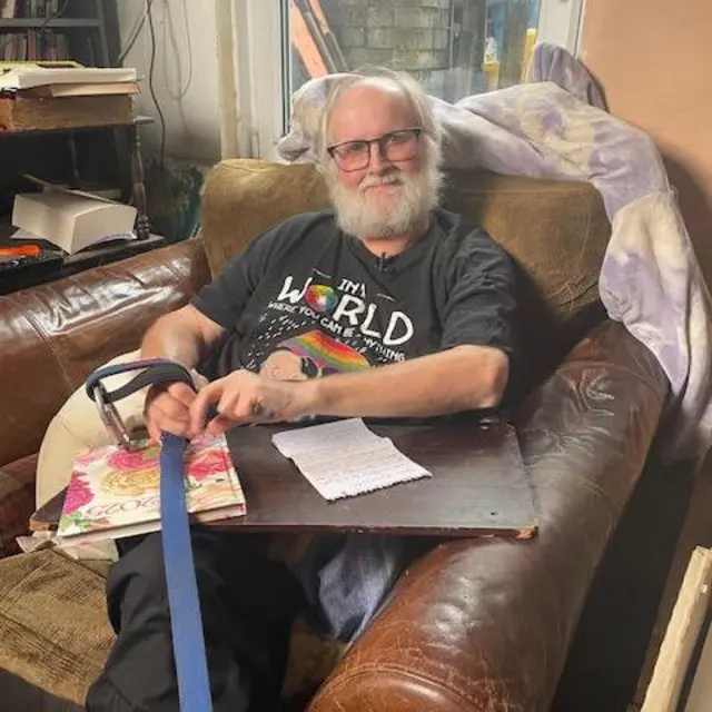 Jeremy Gavins sentado en un sillón de cuero en su casa con una carta en el regazo