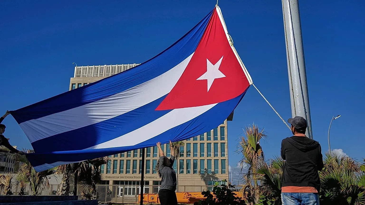 Workers fly the Cuban flag at half-mast in Havana, Cuba, Monday, Jan. 5, 2026, in memory of Cubans who died two days before in Caracas, Venezuela.