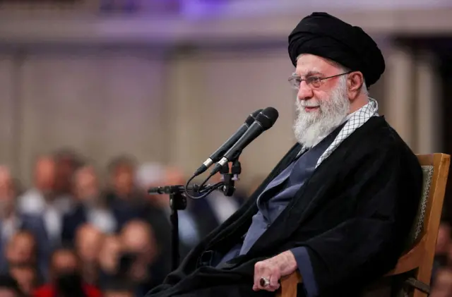 El líder supremo de Irán, Alí Jamenei, sentado junto a un micrófono en un mitin en Teherán. 