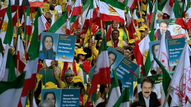 Manifestantes con banderas de Irán y fotografías de Mariam Rayaví.