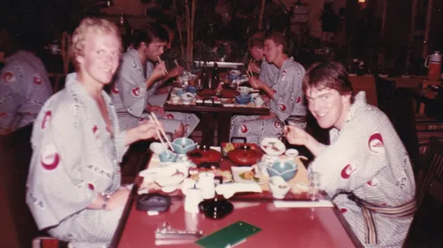 Esta fotografía de 1981muestra a Bjørn-Eirik Olsen (izquierda) sentado a una mesa repleta de platos tradicionales japoneses, vestido con un elegante kimono. Al otro lado de la mesa se sienta un joven, Leif Inge Karlsen, quien posteriormente fundó Hydrotech Salmon Farm, con un kimono idéntico.