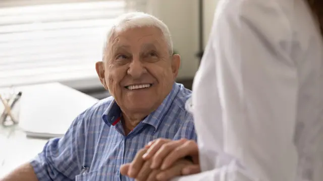una persona mayor sonriendo con una enfermera