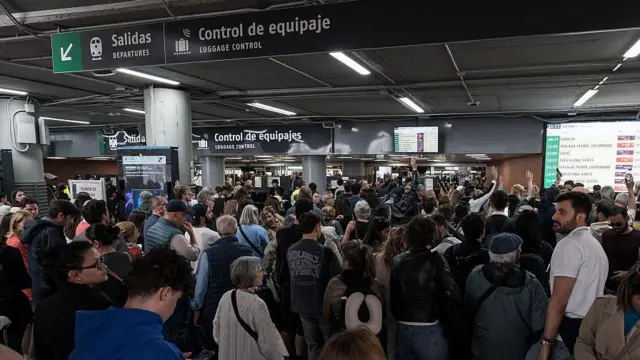 Viajeros se acumulan en las entradas a los andenes en la temporada alta de viajes.