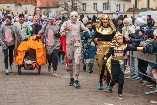 Personas disfrazadas con trajes divertidos participan en la tradicional carrera de Año Nuevo de Cracovia en el casco antiguo, en la víspera de Año Nuevo en Cracovia, Polonia.