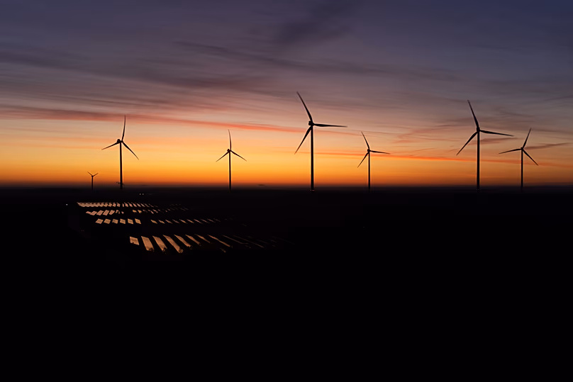 Wind turbines operate as the sun rises at the Klettwitz Nord solar energy park near Klettwitz near Klettwitz, Germany, October 2024.