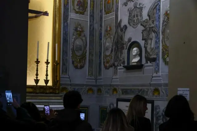 Varias personas toman fotos de la restauración
