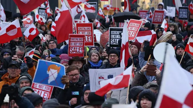Personas con banderas de Groenlandia y carteles que dicen "Groenlandia no está en venta" marchan para protestar contra el presidente estadounidense Donald Trump y su anunciada intención de adquirir Groenlandia, el 17 de enero de 2026, en Nuuk.