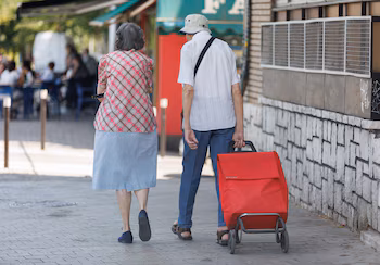 Una pareja mayor caminan con