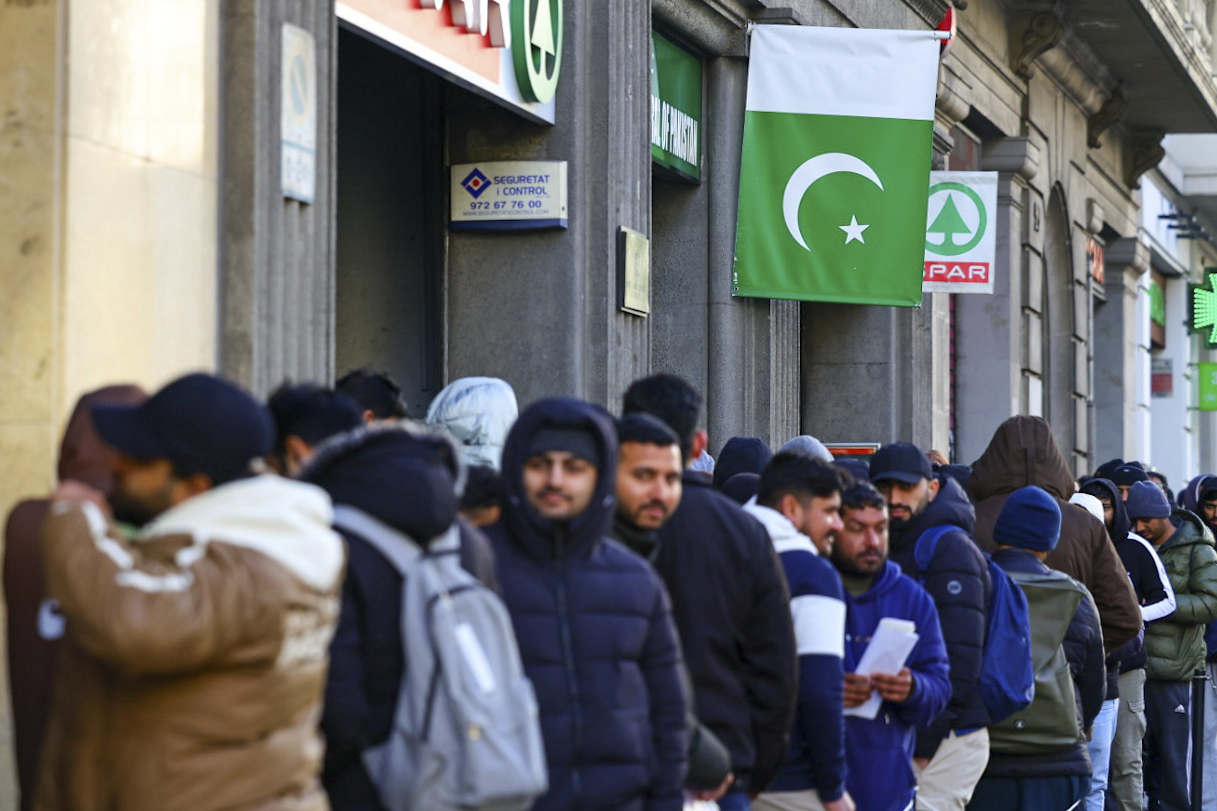 Personas haciendo cola ante el Consulado de Pakistán en Barcelona para acogerse a la regularización extraordinaria.