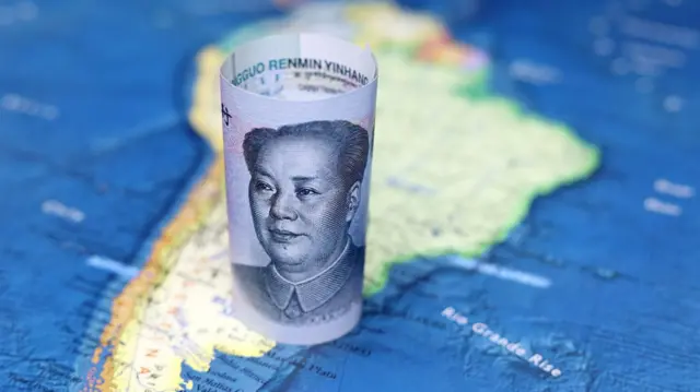 Un billete chino doblado sobre el mapa de América Latina