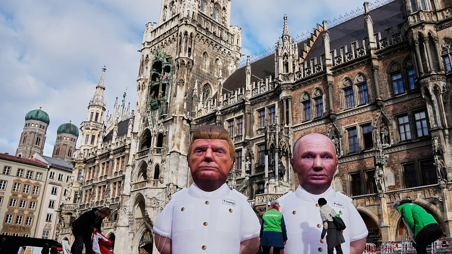 Figures depicting Donald Trump and Vladimir Putin are displayed at a protest in Marienplatz Square during the Munich Security Conference.