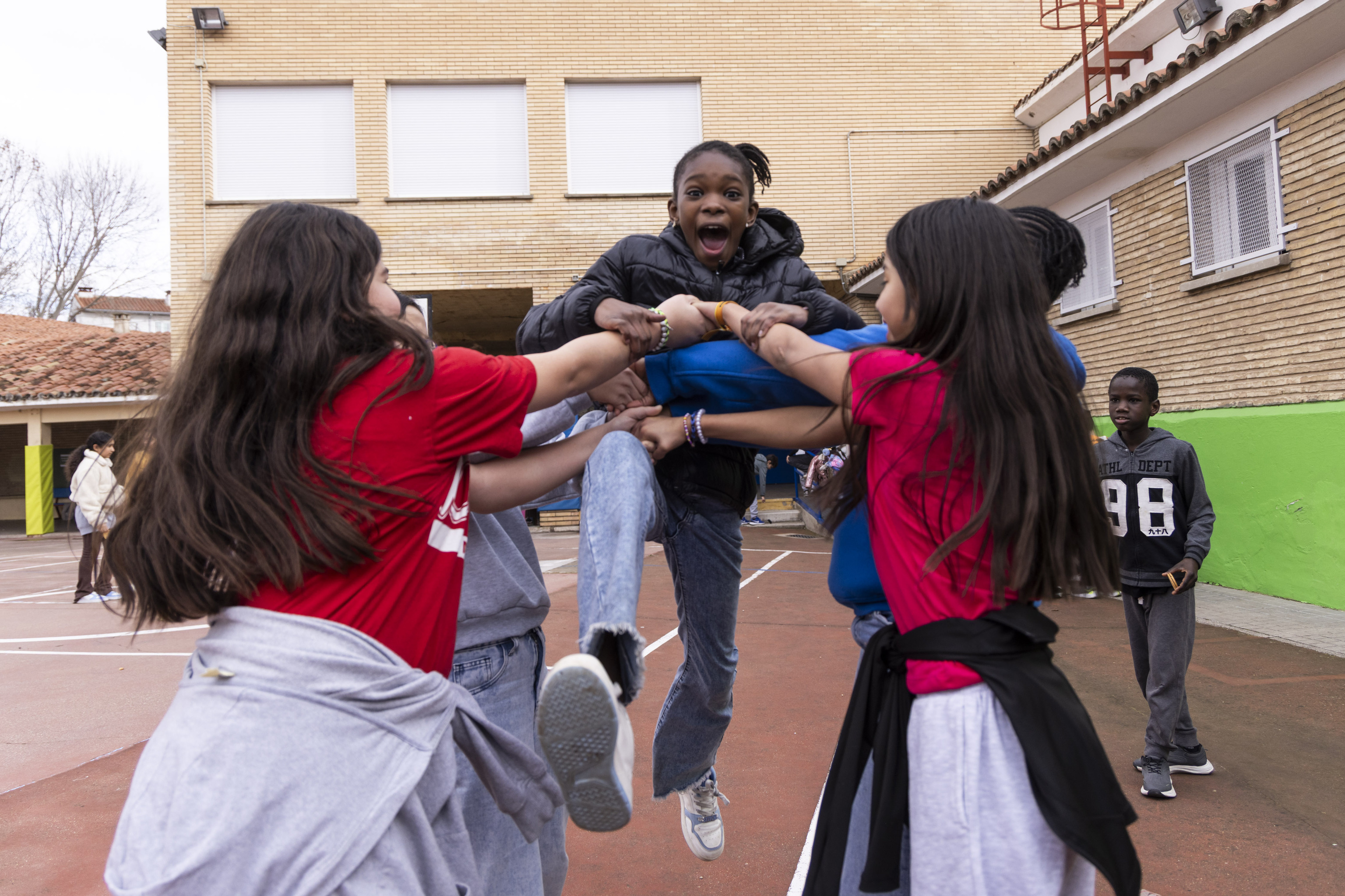 Alumnas del colegio Antonio Beltrán hacen juegos de equipo en el patio.