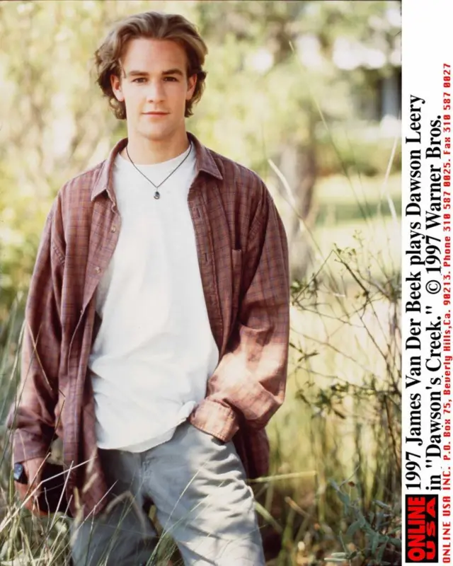 James Van Der Beek, como Dawson Leery, vistiendo una camiseta blanca y una camisa de manga larga a cuadros rojos.