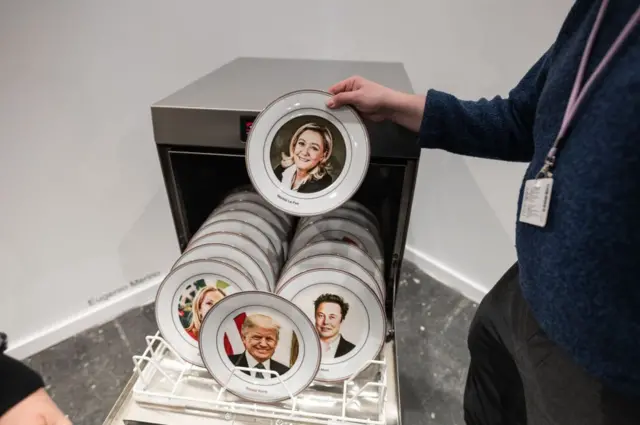 Un plato con el rostro de Marine Le Pen de la obra "White Washing" del artista Eugenio Merino, presentada por la Galería ADN, que consiste en una máquina de lavar platos preparada para el programa de máxima carga con 17 platos impresos con los rostros de los principales representantes de la extrema derecha global, incluyendo a Donald Trump, Elon Musk, Giorgia Meloni, Javier Milei, Marine Le Pen, Jair Bolsonaro, Nigel Farage y Santiago Abascal, entre otros.