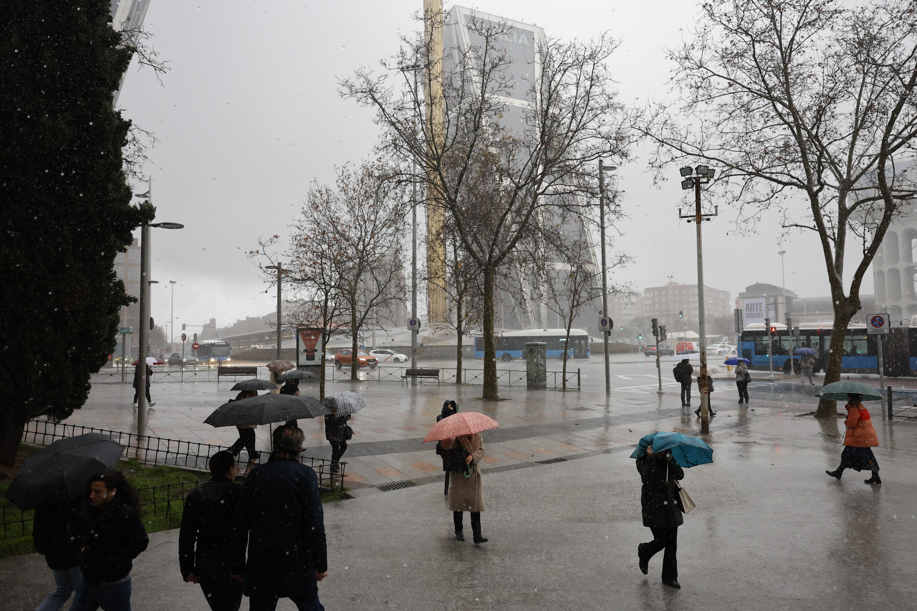 Varias personas se protegen de la lluvia en Madrid, este lunes.