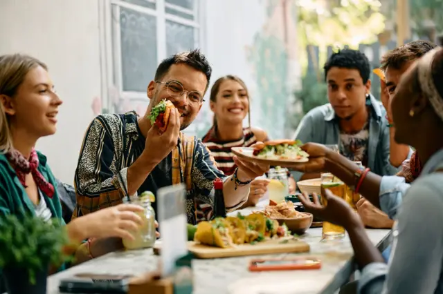 Amigos comiendo y riendo.