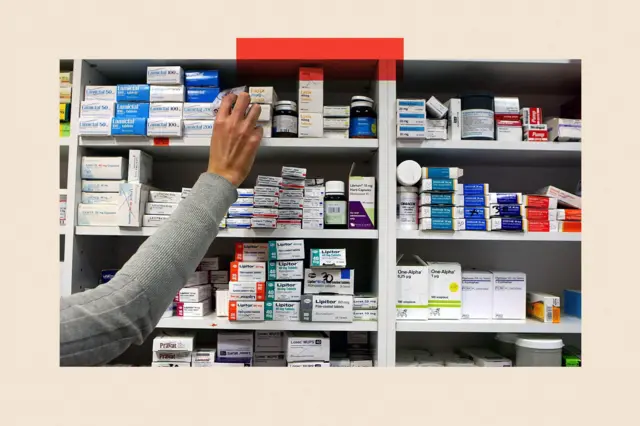 Un farmacéutico repone los estantes de una farmacia.