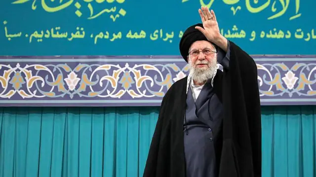 El líder supremo de Irán, Ali Jamenei, que lleva gafas y barba gris y viste largas túnicas oscuras, saluda a la multitud en Teherán.