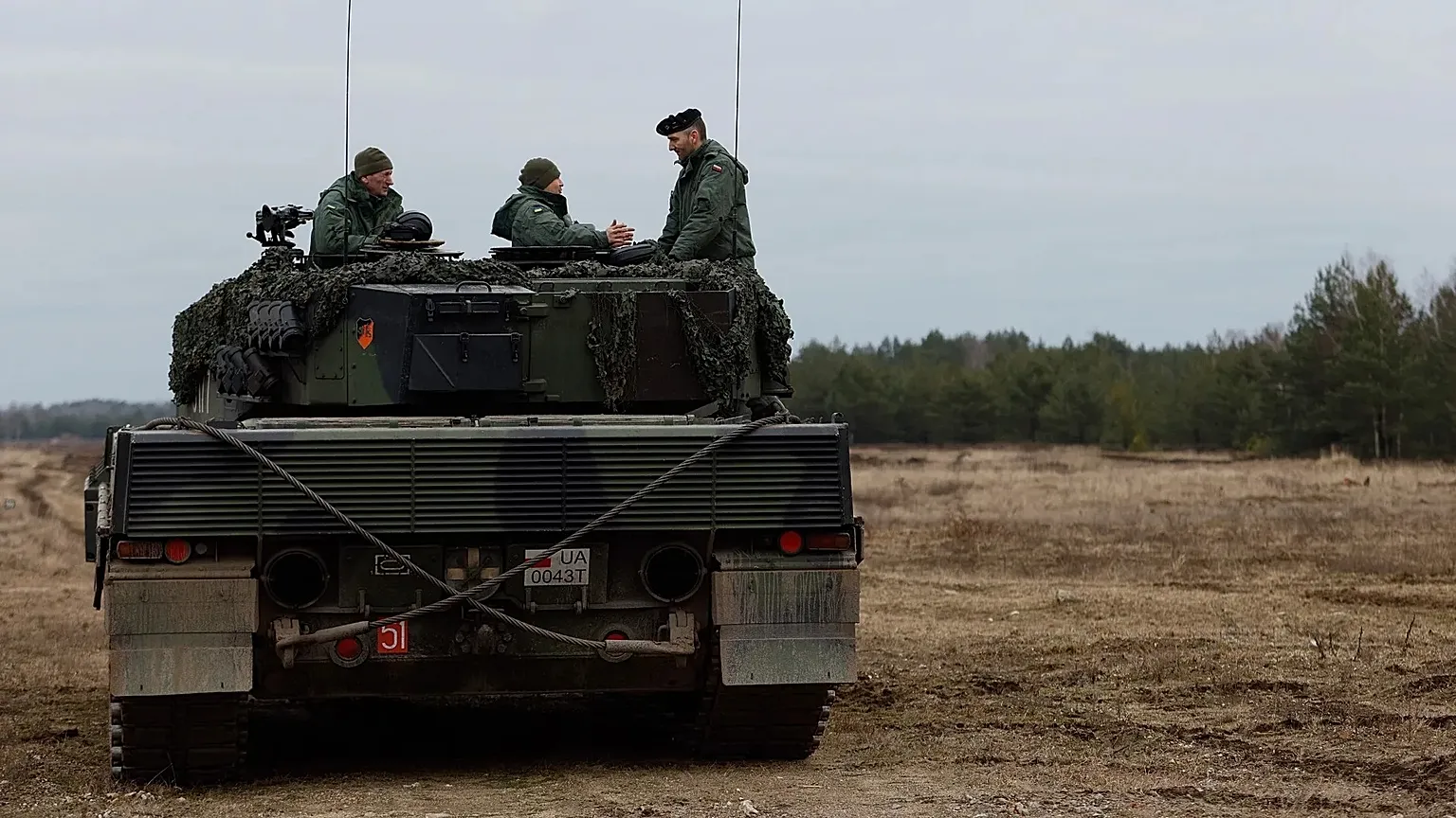 Ukrainian and Polish soldiers sit on top of a Leopard 2 tank during a training at a military base and test range in Swietoszow, Poland, 13 Feb. 2023. 