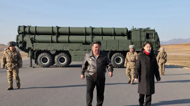 Kim Jong-un, acompañado de su hija Kim Ju-ae, dirige una prueba de un sistema de lanzamiento de cohetes múltiples de gran calibre, en un lugar desconocido en enero. Aparecen delante de un gran camión verde con soldados detrás.
