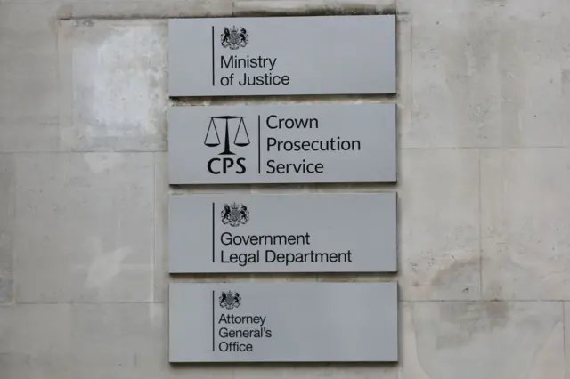 Una pared con distintas placas que identifican oficinas del ministerio de Justicia británico, incluyendo una del Servicio de Fiscalía de la Corona.