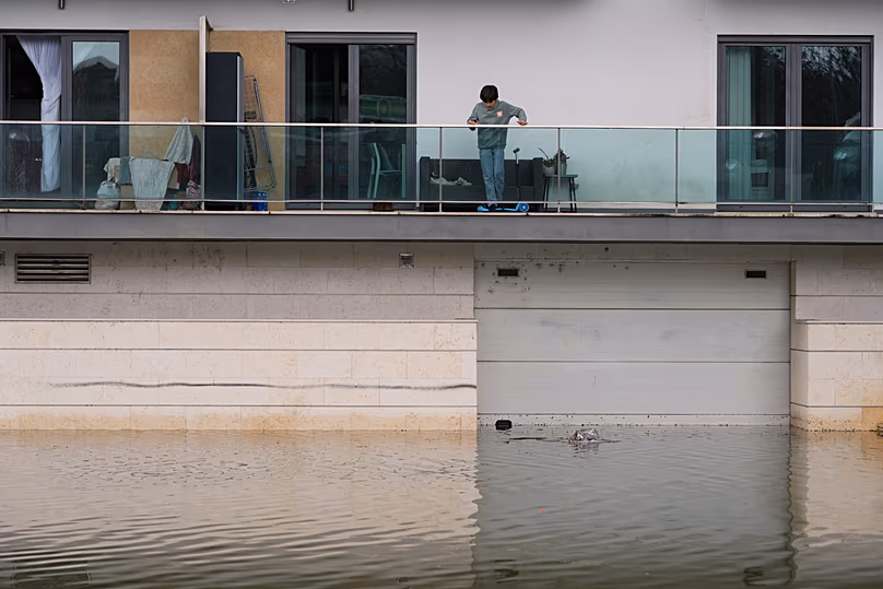 A boy watches floodwaters after heavy rains in Coimbra, Portugal, Friday, Feb. 13, 2026. 