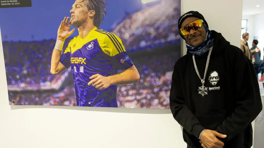 El rapero Snoop Dogg posa junto a una imagen del exfutbolista español Michu, durante su etapa en el Swansea