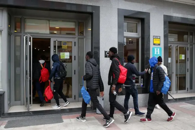 Un grupo de personas entra a un edificio en un hotel Monterroso, Lugo. Son solicitantes de asilo a los que se da allí alojamiento temporal.