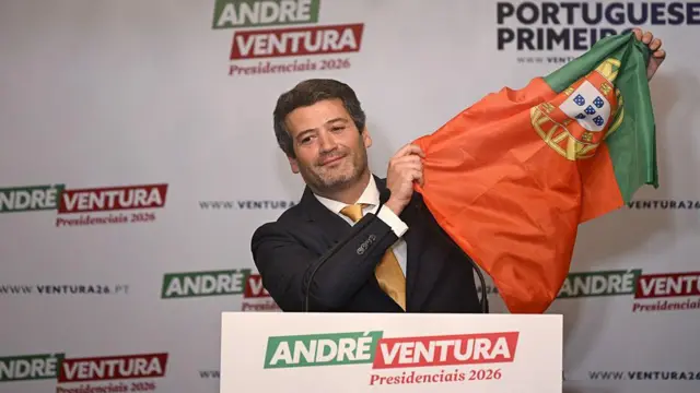 André Ventura levantando una bandera de Portugal.