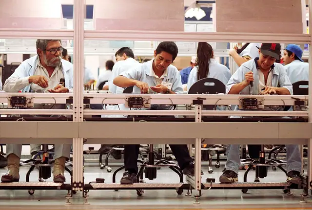 Varios obreros en una maquiladora en México en 2002