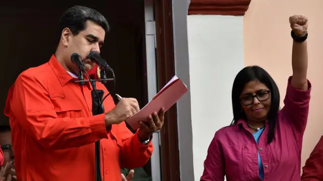 Delcy Rodríguez con el brazo alzado junto a Nicolás Maduro en 2019