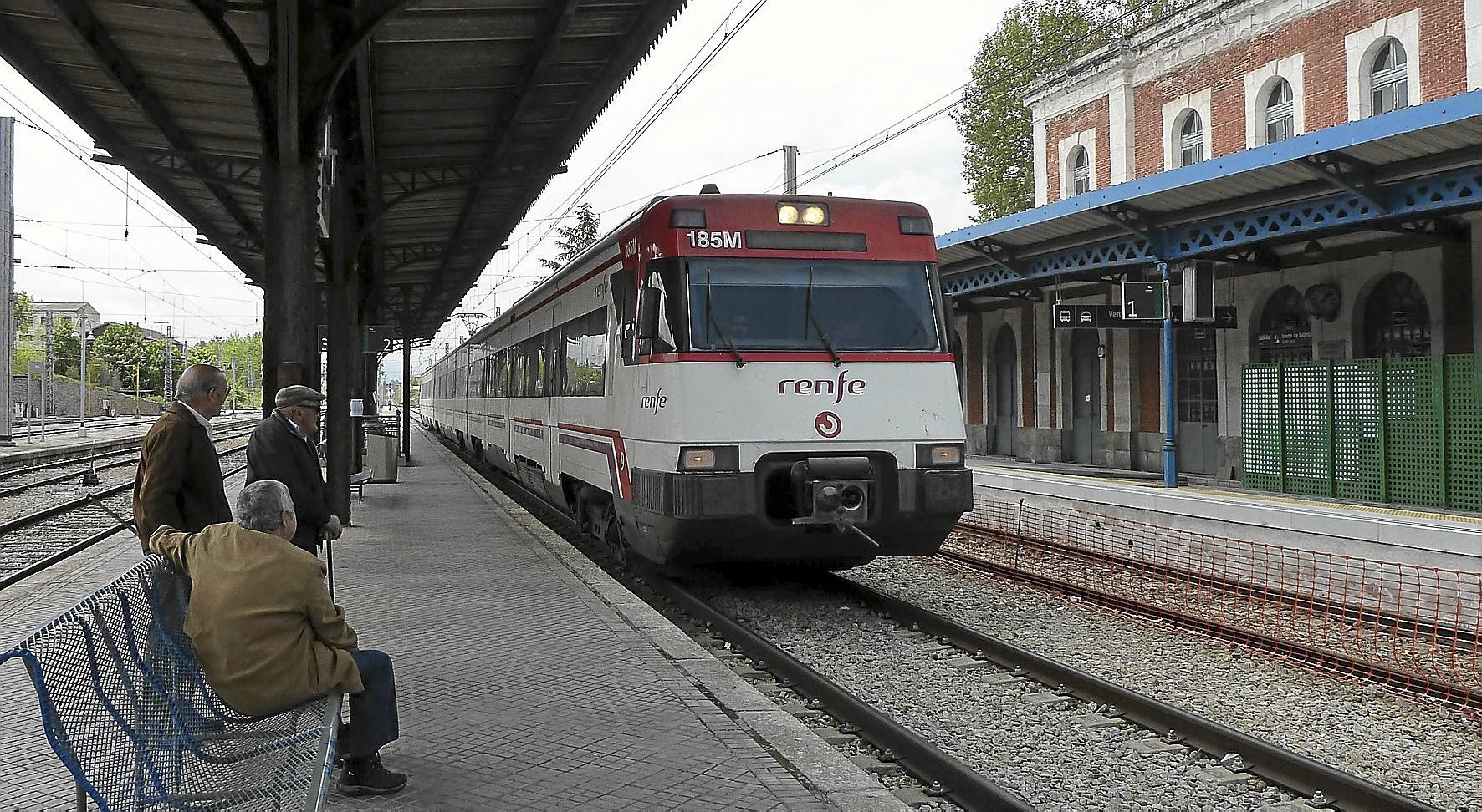 Varias personas esperan en la estación de un tren regional.