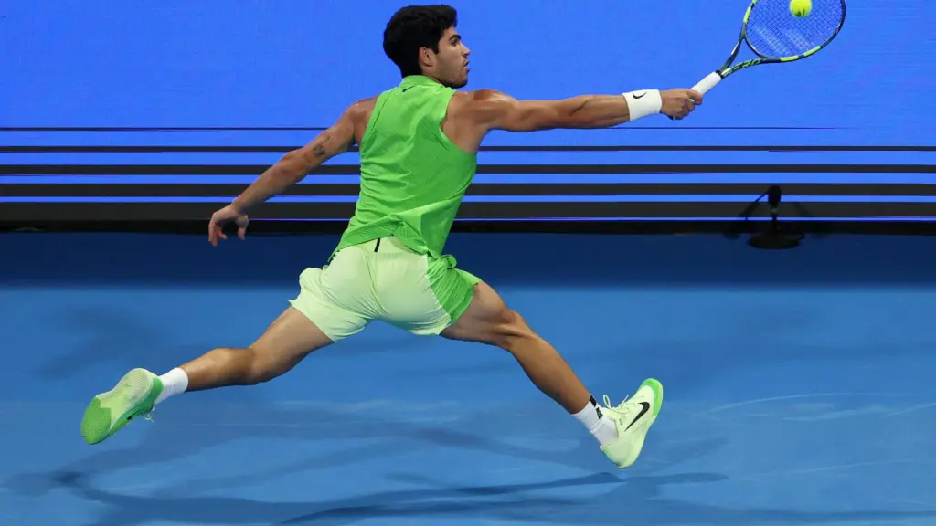 Alcaraz golpea la pelota de espaldas.