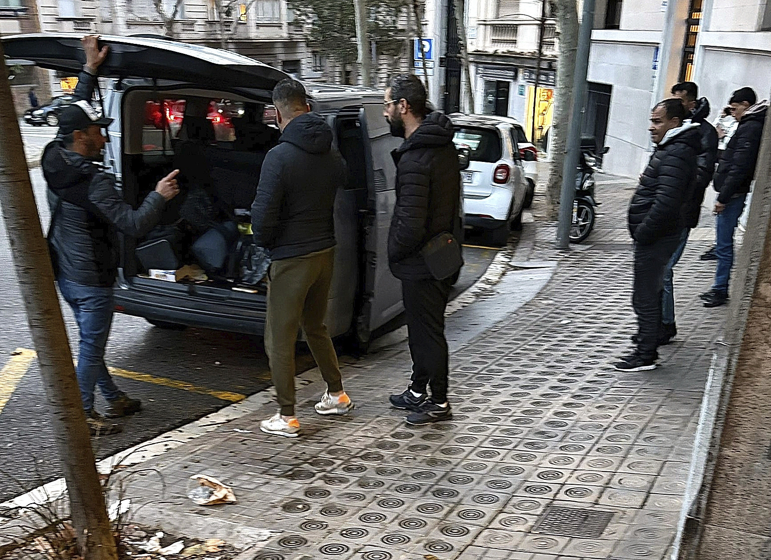 Un grupo de hombres de origen magrebí aparca su furgoneta de matrícula francesa cerca del consulado de Argelia en Barcelona, el pasado martes.